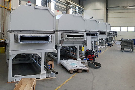 Contract Manufacturing Solarindustrie: Einzelmaschinen für eine 30-m-Kühlstrecke zur Herstellung von Dünnschichtsolarmodulen